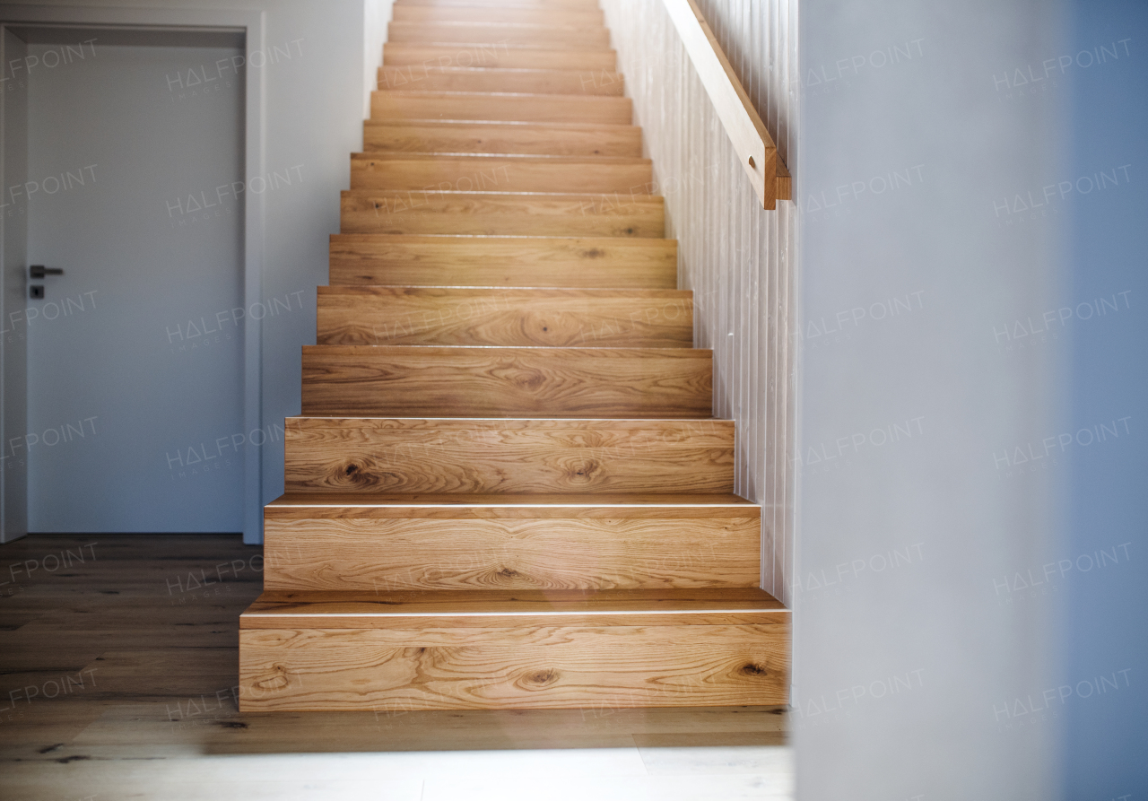 A wooden staircase and white wall in an interior of a house. Copy space.