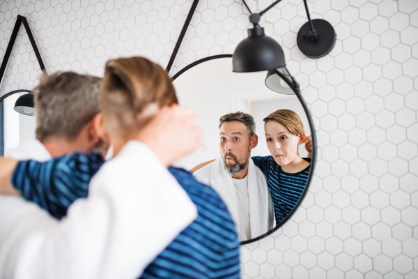 A mature father with small in the bathroom in the morning, grimacing.