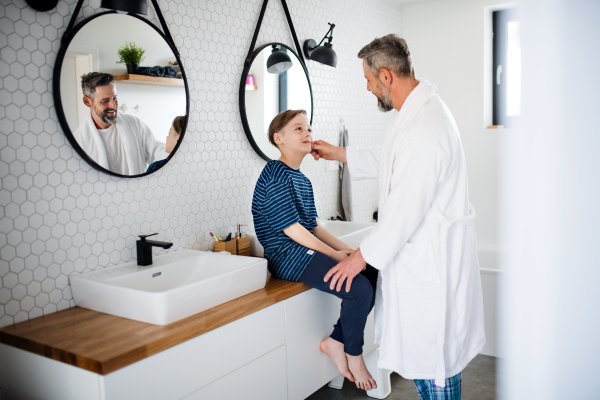 A mature father with small in the bathroom in the morning, talking.