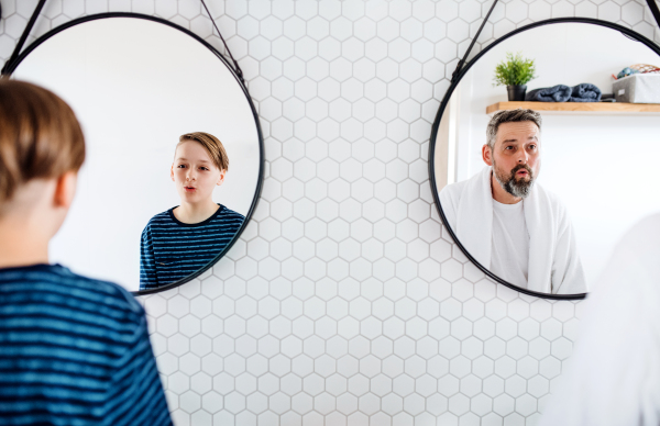 A mature father with small in the bathroom in the morning, grimacing.