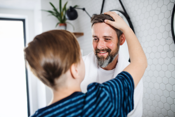 A mature father with small in the bathroom in the morning, talking.