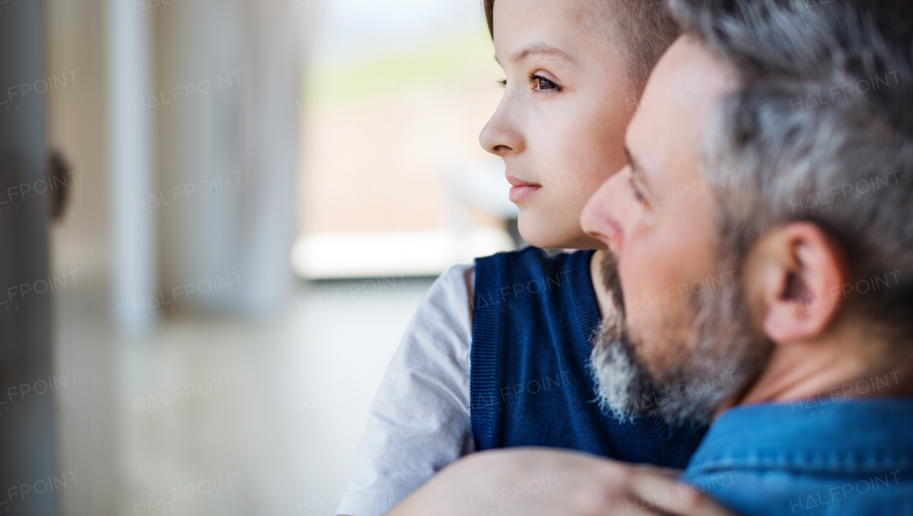 A mature father with small son hugging indoors. Copy space.