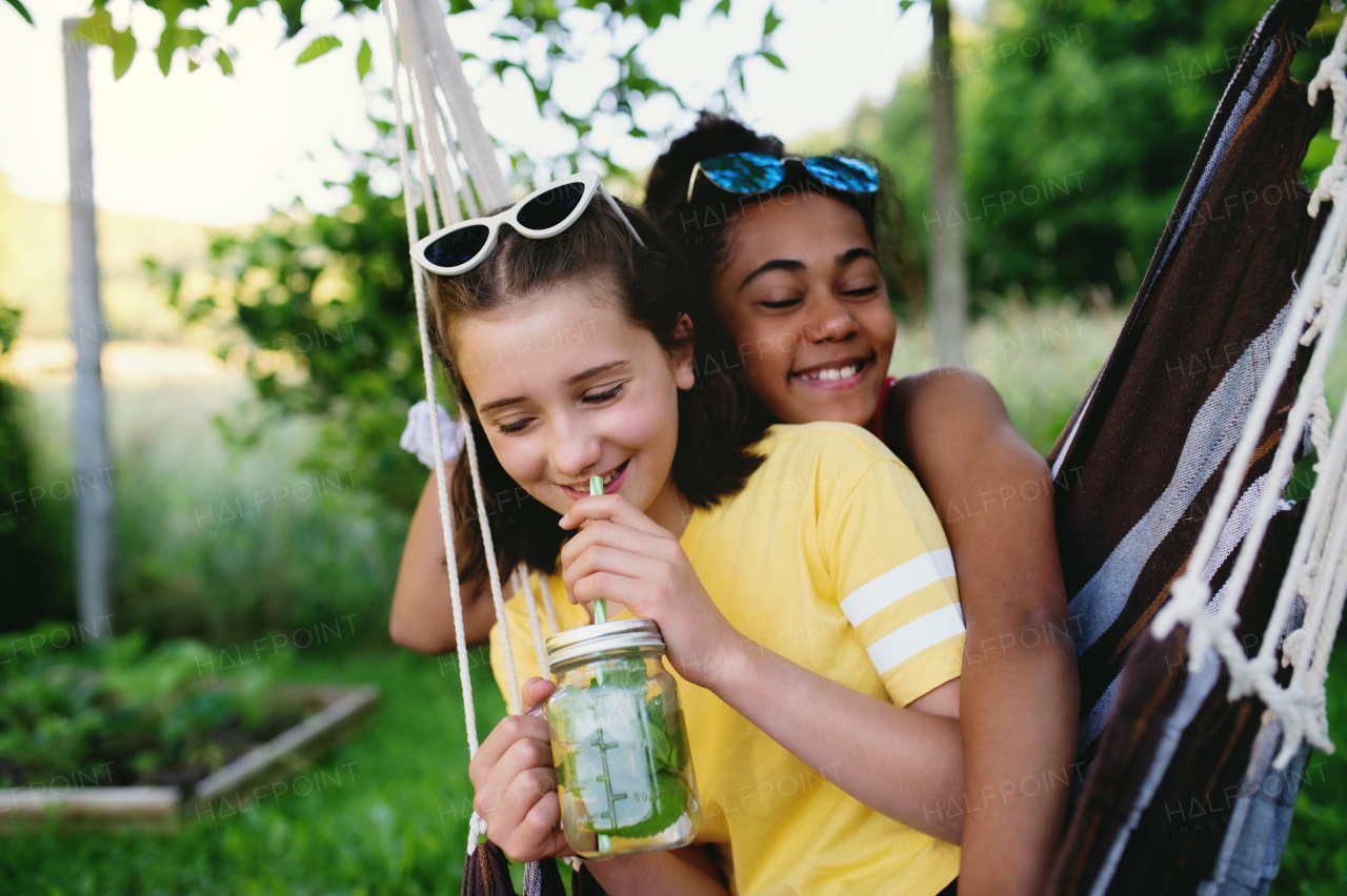 Front view of cheerful young teenager girls friends outdoors in garden, having fun.