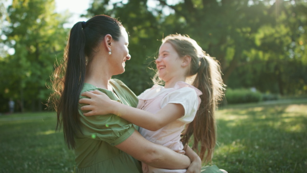 A small girl with her mother resting in a park.