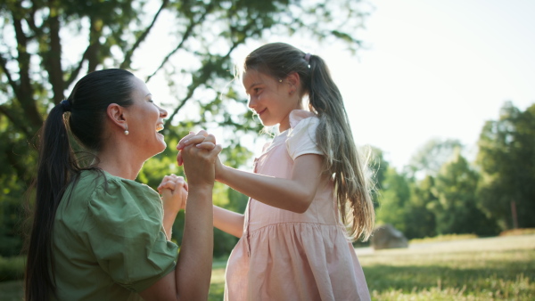 A low angle view of small girl with her mother resting in a park.