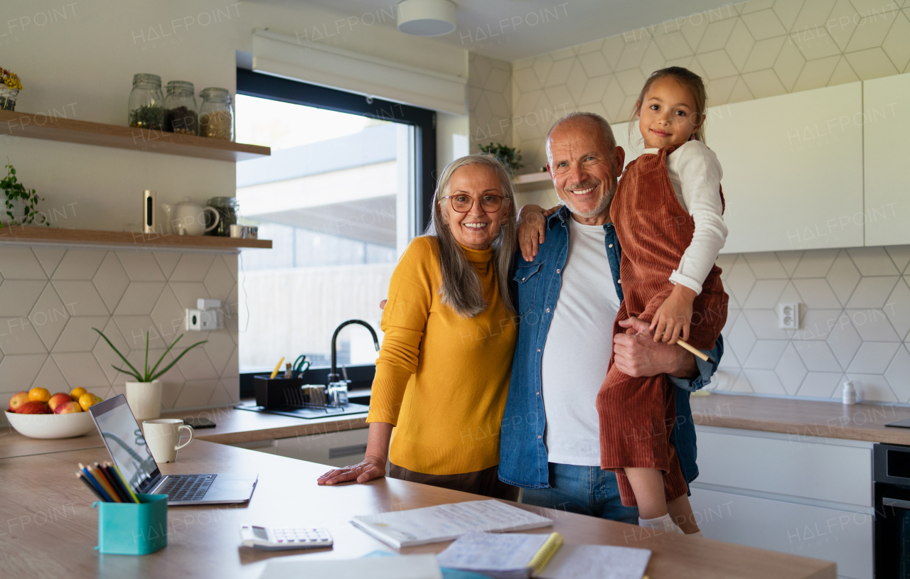 A small girl with senior grandparents doing maths homework at home.