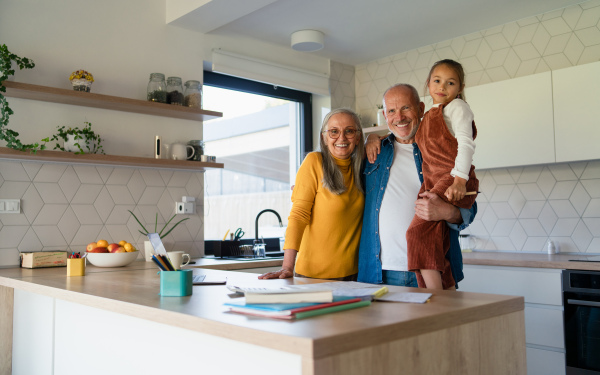 A small girl with senior grandparents doing maths homework at home.