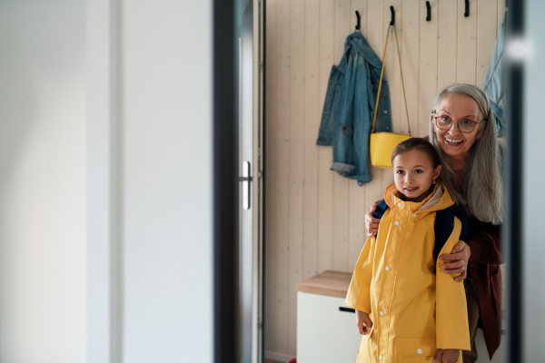 A grandmother helping granddaughter to get ready to leave home for school.