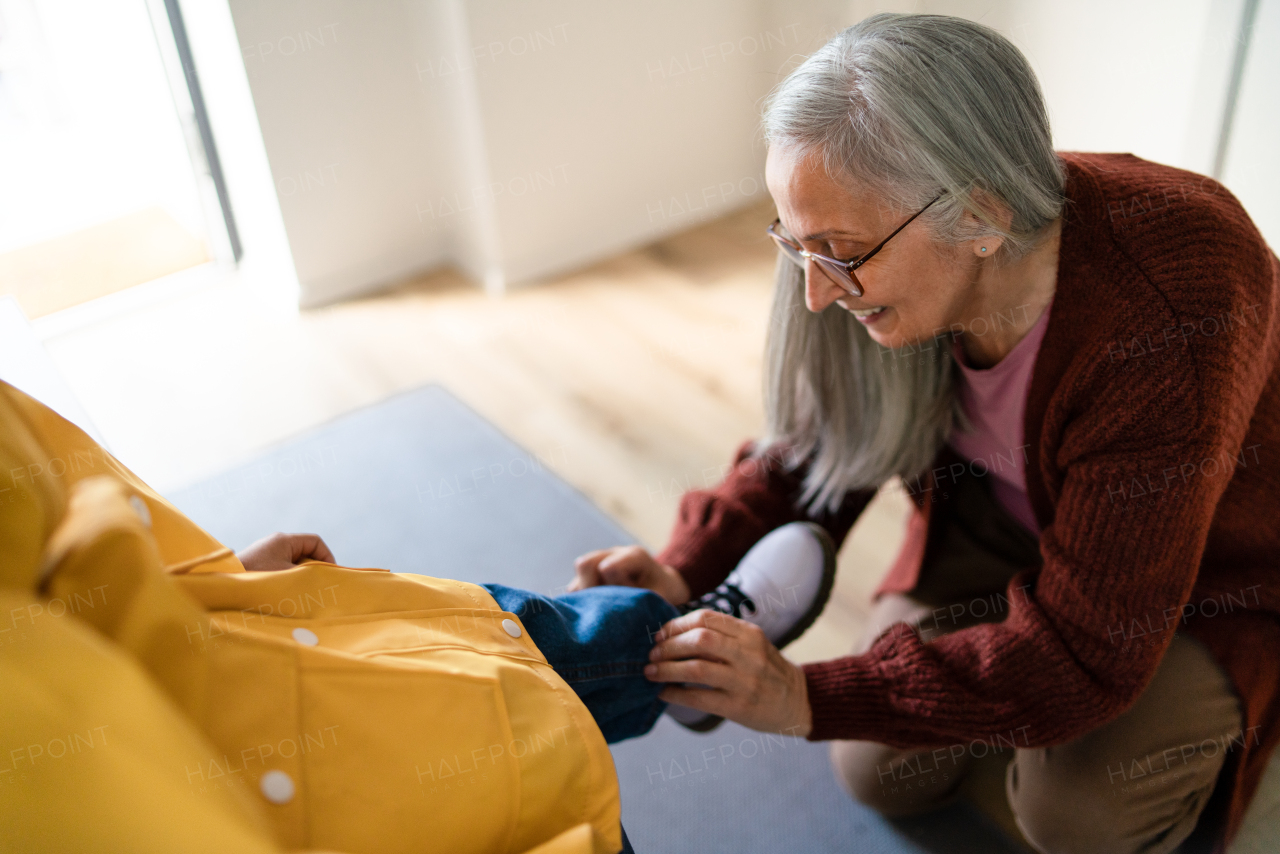 A grandmother helping granddaughter to get ready to leave home for school.