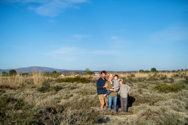 Young family with two small children standing outdoors in nature in Greece.