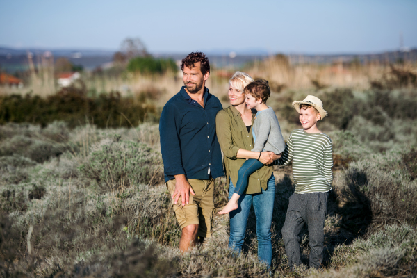 Young family with two small children standing outdoors in nature in Greece.