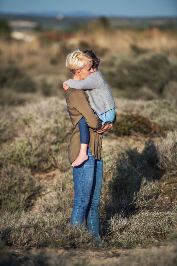 A side view of young mother with small daughter in mediterranean nature.