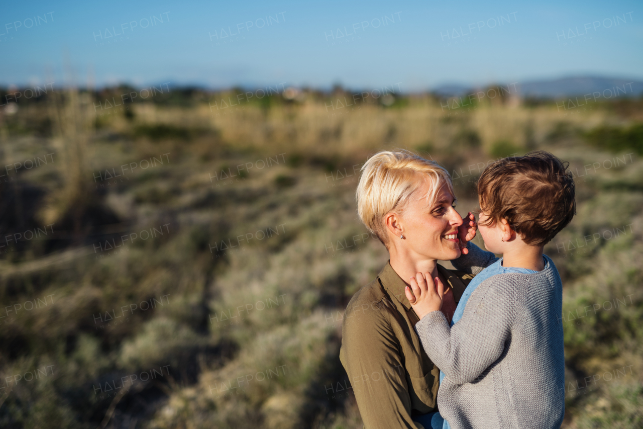 Portrait of young mother with small daughter in mediterranean nature. Copy space.