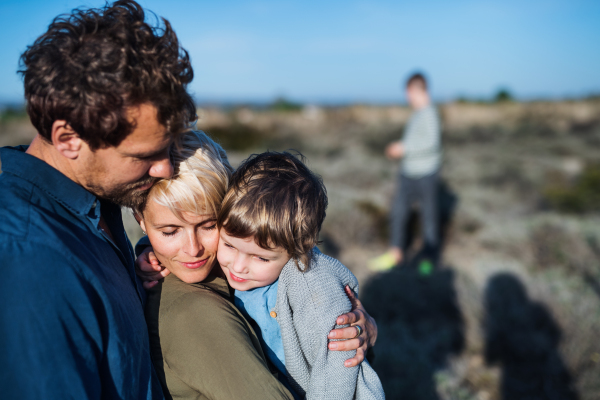 Young family with two small children standing outdoors in nature in Greece.