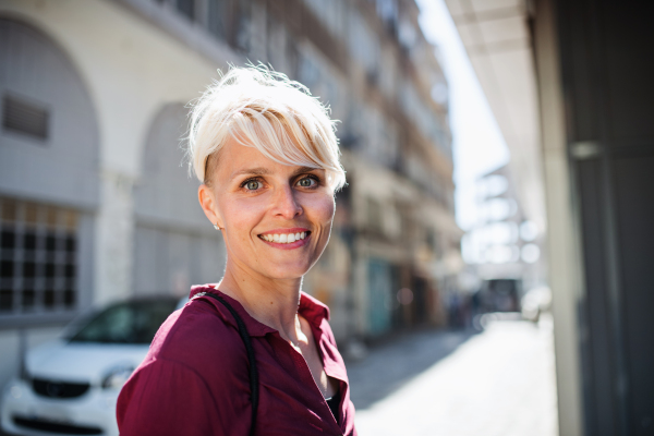 A portrait of attractive woman standing outdoors in town. Copy space.