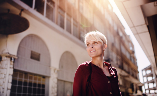 A portrait of attractive woman standing outdoors in town. Copy space.