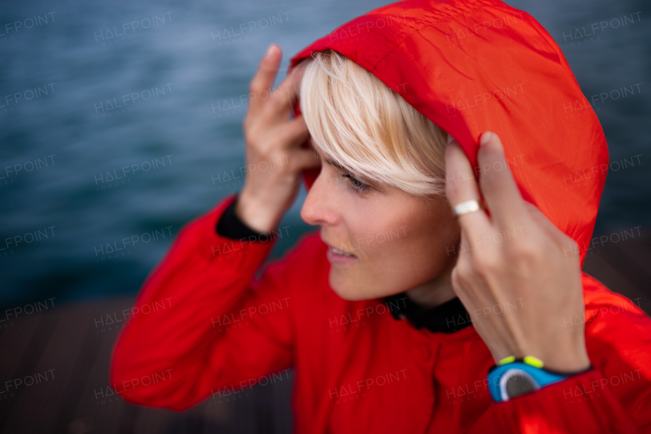 Portrait of young sportswoman standing outdoors on beach, headshot.