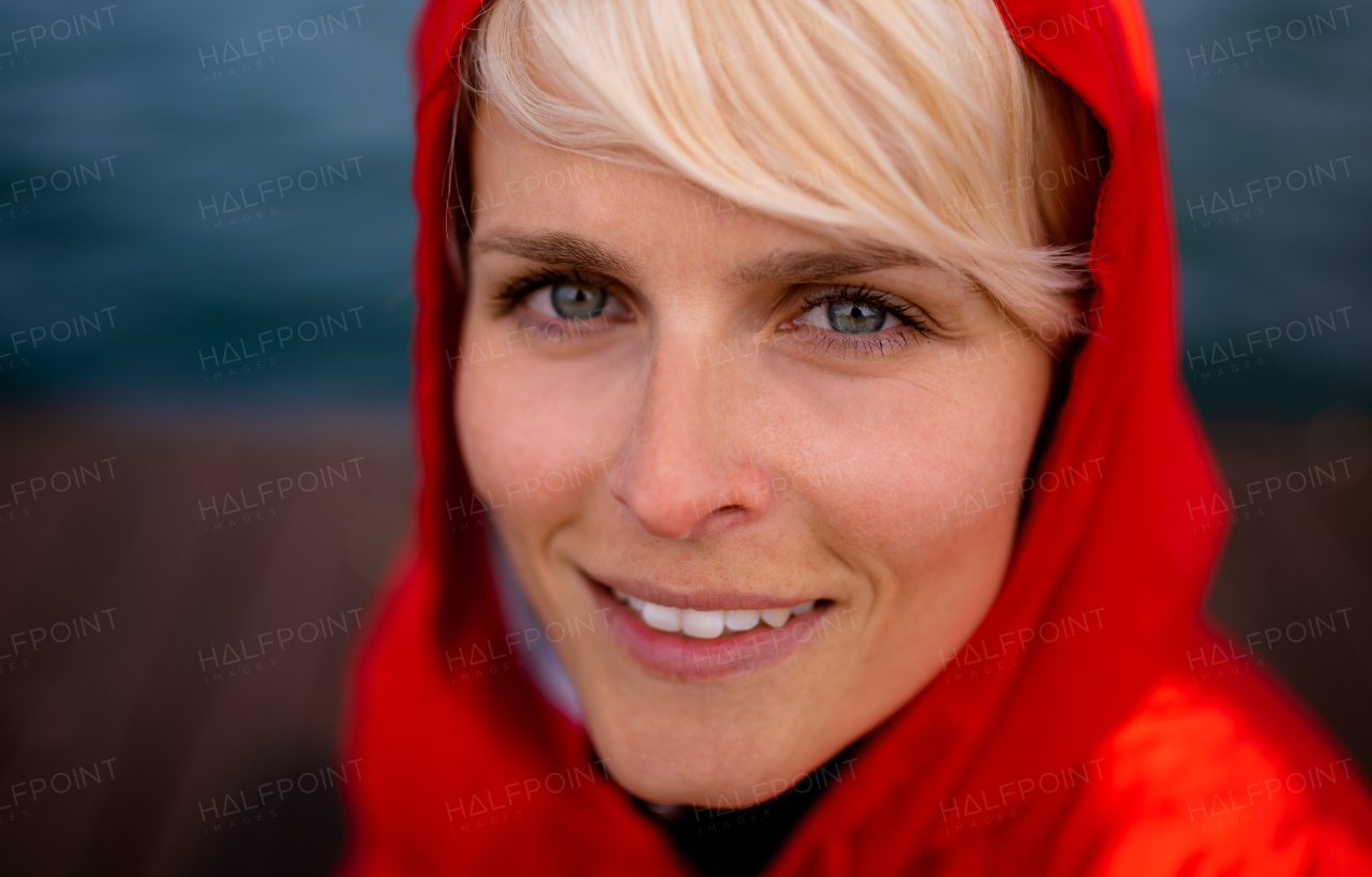 A close-up portrait of young woman standing outdoors on beach.