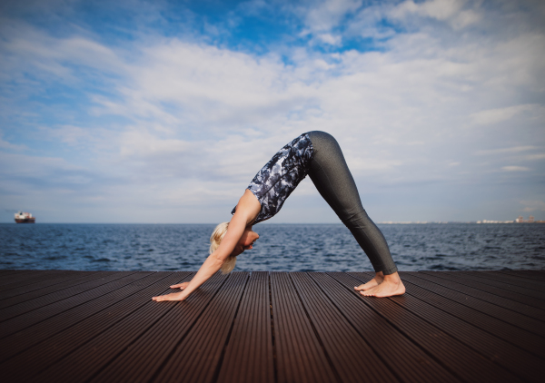 Front view portrait of young sportswoman doing exercise on beach. Copy space.