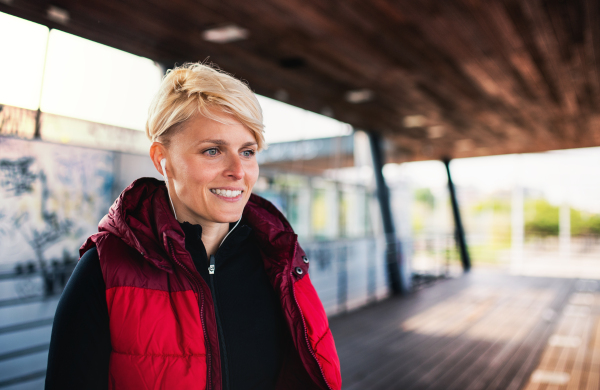 A portrait of young sportswoman doing exercise outdoors, resting. Copy space.