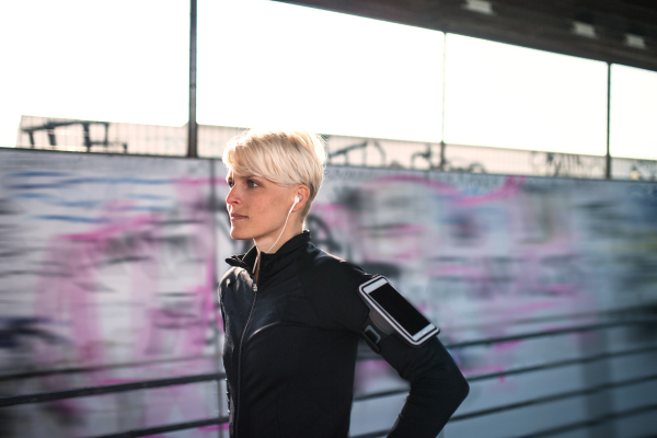 A portrait of young sportswoman resting after doing exercise outdoors. Copy space.