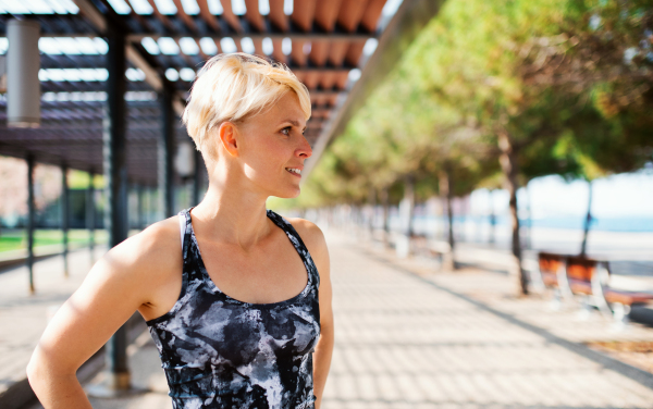 A portrait of young sportswoman resting after doing exercise outdoors. Copy space.