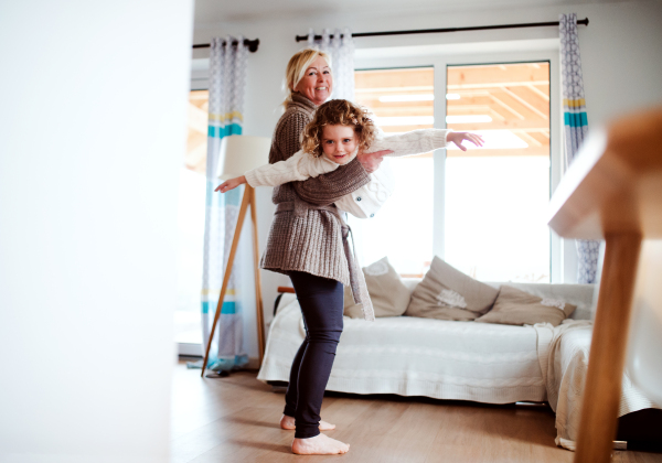 A portrait of small girl with grandmother having fun at home. Copy space.