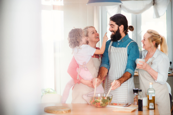 A portrait of small girl with parents and grandmother at home, preparing vegetable salad.