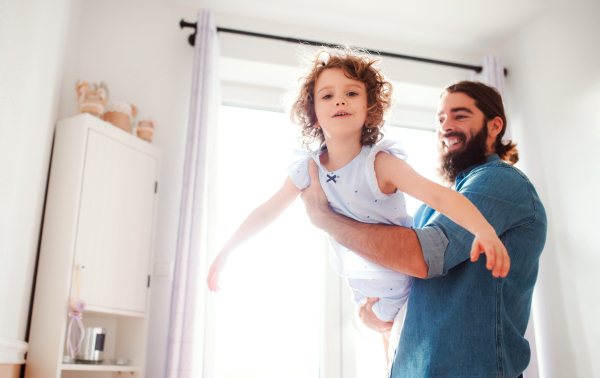 A small girl with young father in bathroom at home, having fun.