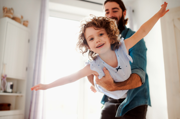 A small girl with young father in bathroom at home, having fun.