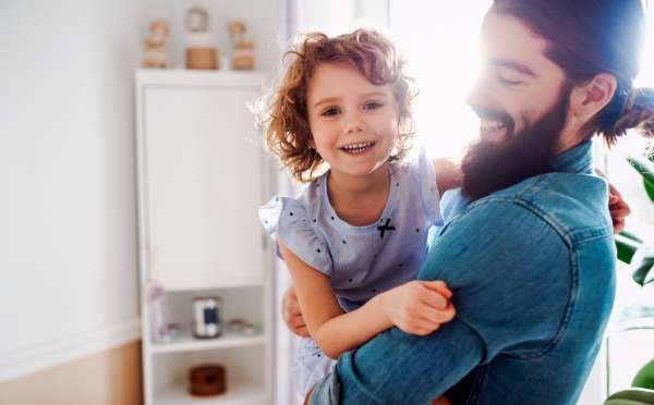 A small girl with young father in bathroom at home, having fun.