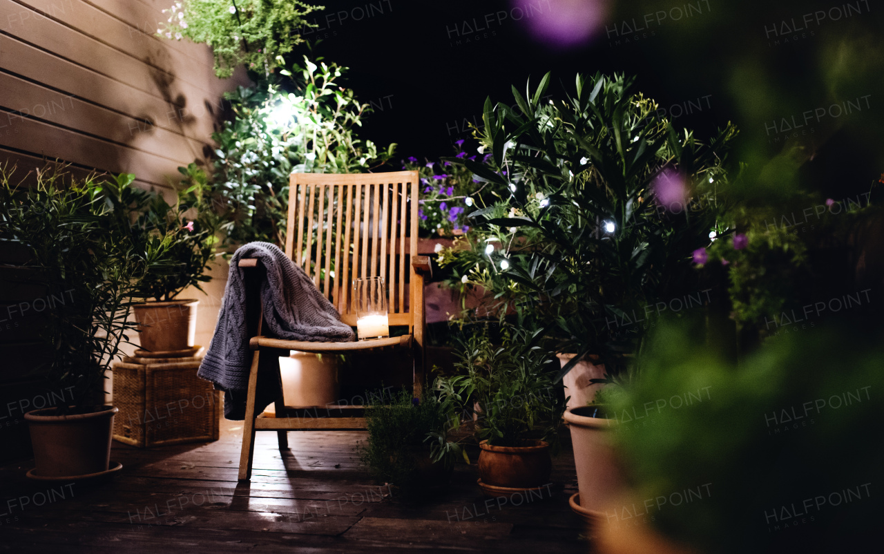 Candle on chair in the evening on house terrace in summer.