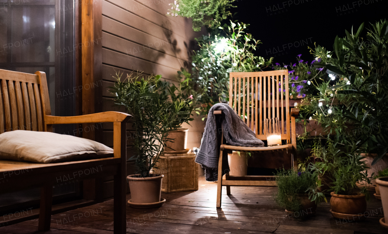 Candle on chair in the evening on house terrace in summer.