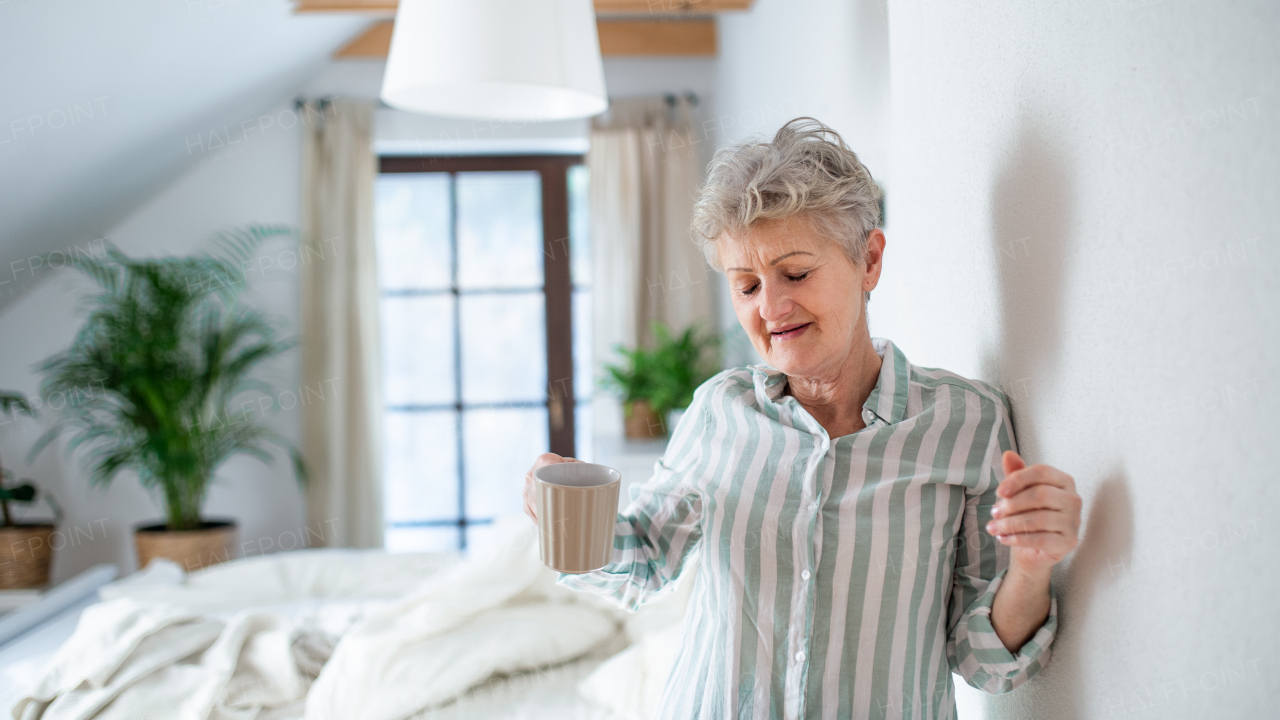 Happy senior woman in bed at home getting up in the morning.