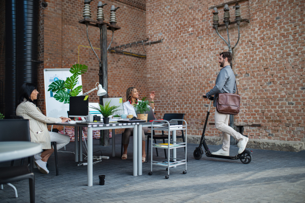 Young and old businesspeople working in office, a cooperation and eco commuting concept.