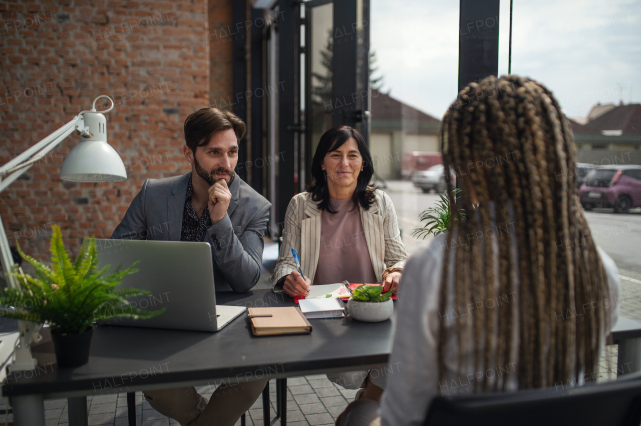 A rear view of young woman having job interview in office, business and career concept.