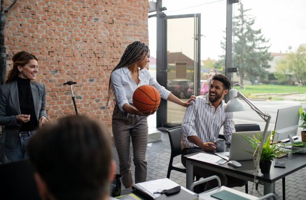 Cheerful young businesswoman having fun with a ball in office, take a break concept.