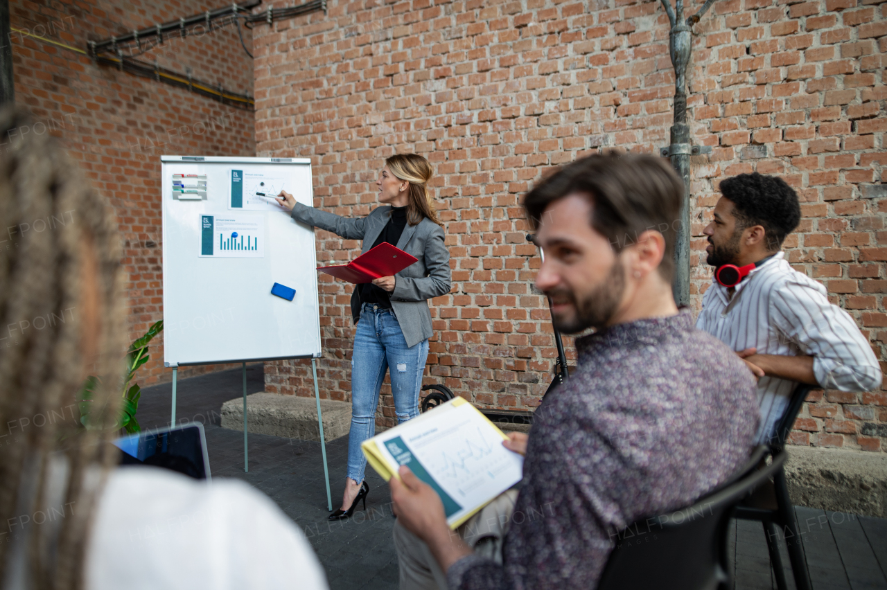 Young businesspeople standing and working in office, cooperation, presentation and a brainstorming concept.