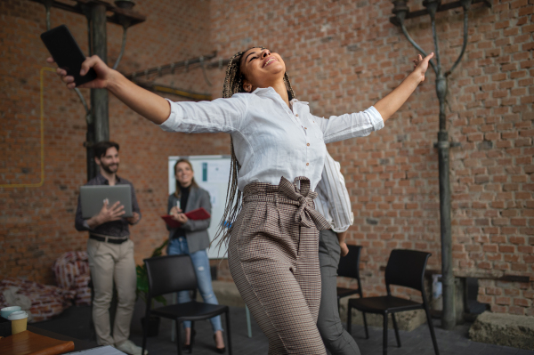 Cheerful young businesspeople having fun in office, a cooperation and brainstorming concept.