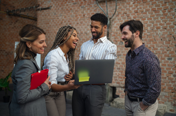 Cheerful young businesspeople standing and working in office, a cooperation and brainstorming concept.