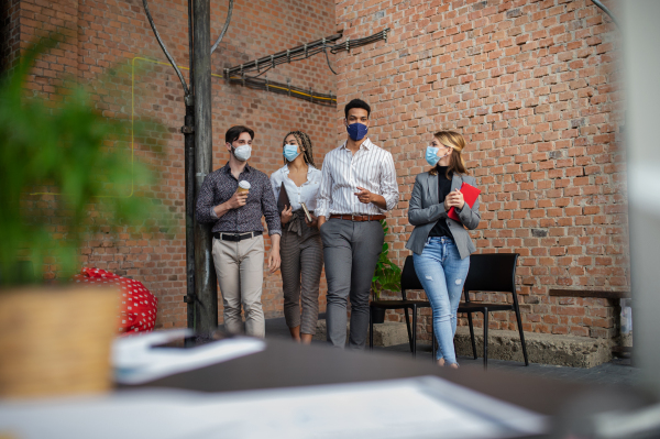 Group of businesspeople feeling joyful in an office, cooperation and coronavirus concept.