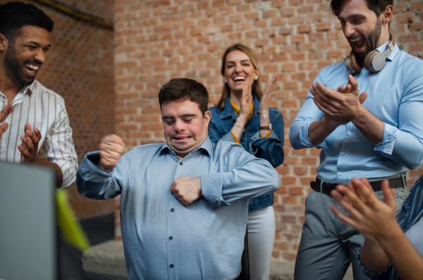 Cheerful young businesspeople having fun in a office, social inclusion and cooperation concept.