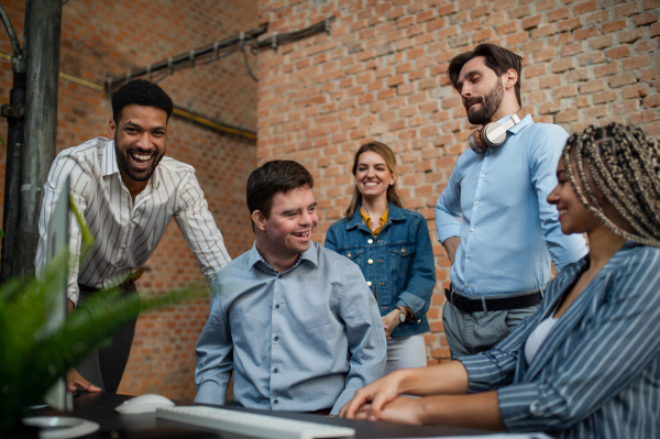 Cheerful young businesspeople having fun in a office, social inclusion and cooperation concept.