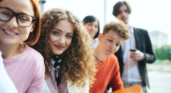 A portrait of businesspeople entrepreneurs outdoors indoors in office, looking at camera.