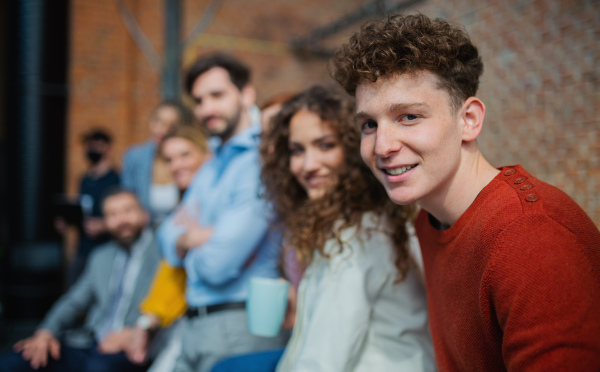 A portrait of businesspeople entrepreneurs outdoors indoors in office, looking at camera.