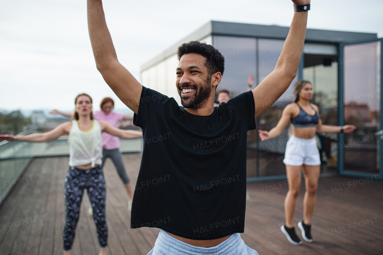 A group of young people doing exercise outdoors on terrace, sport and healthy lifestyle concept.