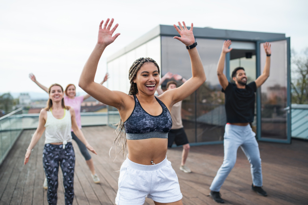 A group of young people doing exercise outdoors on terrace, sport and healthy lifestyle concept.