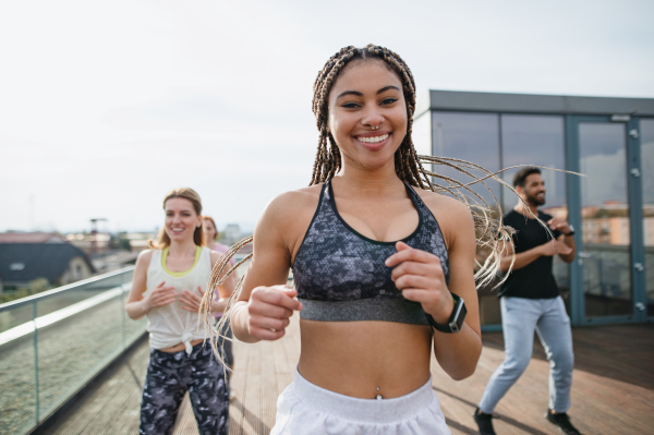 A group of young people doing exercise outdoors on terrace, sport and healthy lifestyle concept.