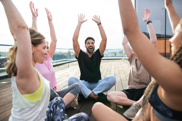 A group of young people doing exercise outdoors on terrace, sport and healthy lifestyle concept.