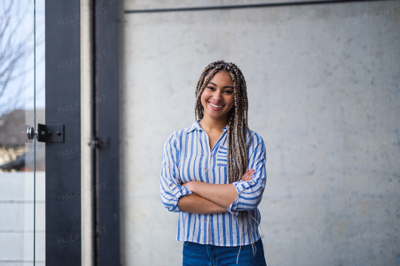 A portrait of woman freelancer standing indoors in office, looking at camera.